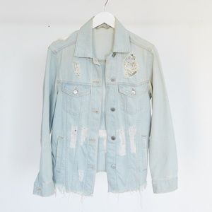 Distressed denim jacket with hand stitched patch